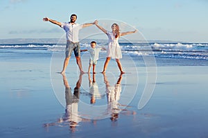 Happy family walking with fun on sunset sea beach