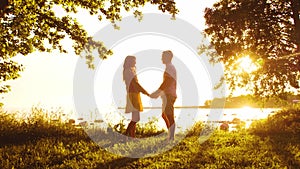 Happy family walking near the sea. Field and trees in countryside. Warm colors of sunset or sunrise. Loving parents and