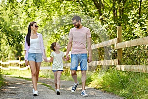 Happy family walking in summer park