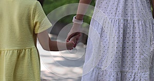 Happy family walking in summer park. Mother and daughter spending time together and holding hands outdoor. 4k Slow
