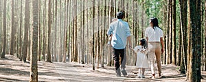 Happy family walking through the sunny forest