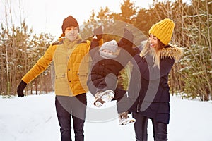 Happy family walking in winter day in forest. Family, weekend and holiday concept