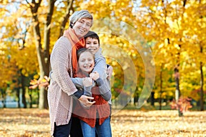 Happy family walks in autumn city park. Children and parents posing, smiling, playing and having fun. Bright yellow trees.