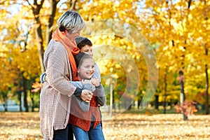 Happy family walks in autumn city park. Children and parents posing, smiling, playing and having fun. Bright yellow trees.