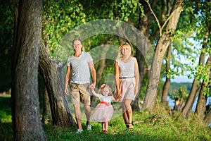 Happy family walks in a lakeside park