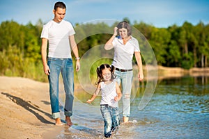 Happy family walks on the nature near the lake