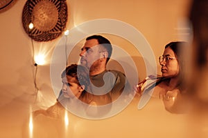 Happy family watches TV in the evening in their living room