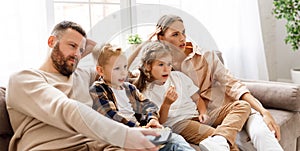 Happy family watching an exciting action-Packed movie on TV together