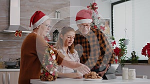 Happy family watching online childhood xmas video using tablet computer