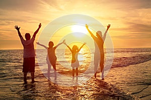 Happy family watching the sunset on the beach