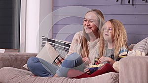 Happy family watching television together on sofa