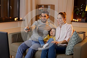 Happy family watching tv at home at night
