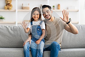 Happy family waving hands and posing at camera