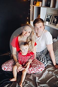 Happy family wearing pajamas spending time together in Christmas morning.