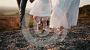 Happy family on weekend went to nature and at sunset walk in field on gravel