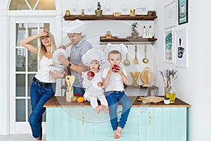 Happy family in white caps with two kids cooking at home food.