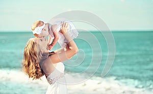 Happy family in white dress. Mother throws up baby in the sky