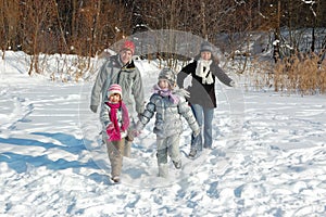 Happy family in winter, having fun and playing with snow outdoors on holiday weekend