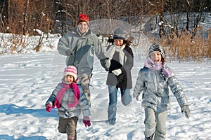 Happy family in winter, having fun with snow outdoors
