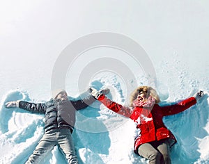 Happy family in winter time! mother with son child lying on snow