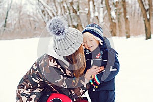 Happy family on a winter walk. Young mother and baby boy playing in snow. Frost winter snowy season. Happy child with mom enjoing