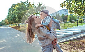 Happy family woman mom and little boy son, play and have fun, autumn day on street in city park. Emotions of joy of fun