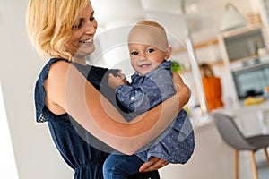 Happy family. Mother and baby daughter plays, hugging, kissing at home