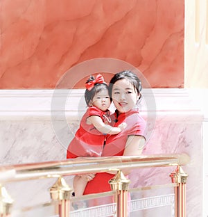 happy family young Chinese mother has fun with baby in China traditional cheongsam
