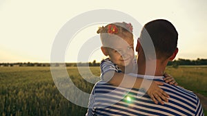 Happy family. A young father holds a child in his arms. Father and daughter hug each other in the open air in the rays