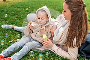 Happy family, young mother woman, little boy son 3-6 years old, emotions delight joy positive. Blow air bubbles, play
