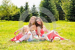 Happy family. Young mothers and kids boy and girl on sunny day. Portrait moms and children on nature. Positive human emotions, fee