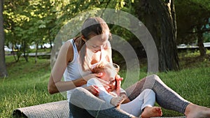 Happy family of young sporty mother and little cute daughter having fun outdoors