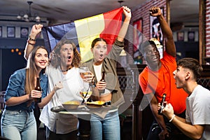 Happy fans celebrating the victory of Belgian team in bar