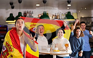 Happy fans celebrating the victory of Spanish team in bar