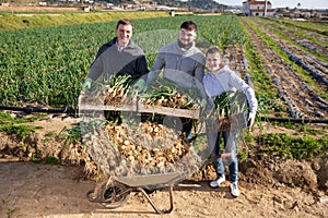 Happy farm family with freshly harvested scallions