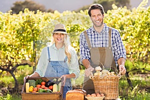 Happy farmer couple presenting their local food