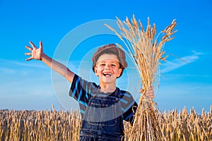 Happy farmer's boy on wheat field