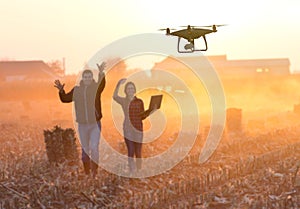 Happy farmers waving hands to drone