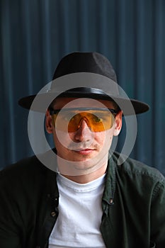 Happy fashion man. Portrait of handsome smiling stylish hipster lambersexual model. Man dressed in yellow sunglasses and