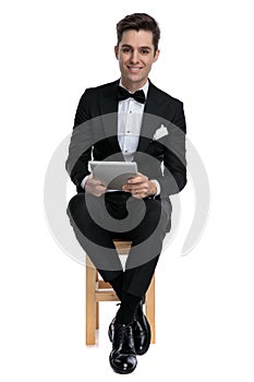 Happy fashion model in tuxedo holding tab