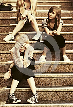 Happy fashion teen girls sitting on steps