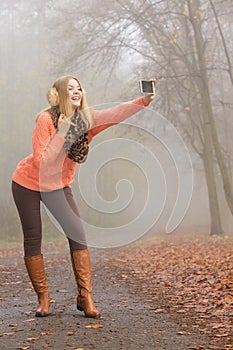 Happy fashion woman in park taking selfie photo