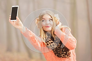 Happy fashion woman in park taking selfie photo.