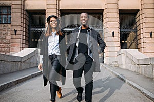 Happy fashionable pedestrians on city street