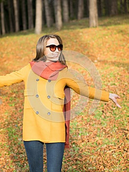 Happy fashionable young woman walking in autumn park
