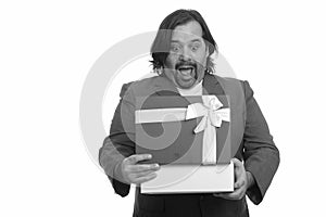 Happy fat Caucasian businessman smiling opening gift box