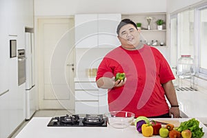 Happy fat man preparing to make a healthy salad