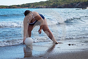 Happy fat woman playing ball on the beach