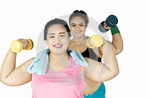 Happy fat women lifting dumbbells