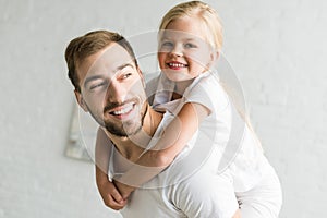 Happy father and adorable little daughter hugging and having fun